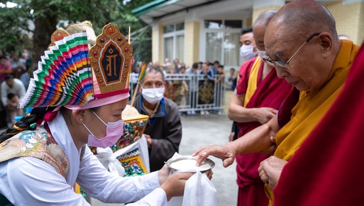チベットの若者たちに向けた法話会の初日に、ツクラカンの中庭に到着された法王を、“チェマル・チャンプー” を捧げて歓迎する伝統的な衣装に身を包んだチベット人たち。2023年5月30日、インド、ヒマーチャル・プラデーシュ州ダラムサラ（撮影：テンジン・チュンジョル / 法王庁）